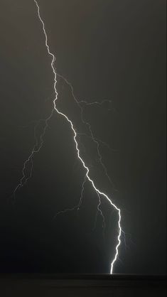 lightning strikes across the night sky over water