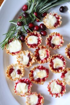 cranberry and cheese appetizers on a plate with rosemary sprigs