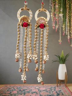 two gold and white chandeliers hanging from the ceiling in front of a rug