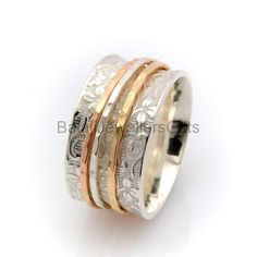 three different colored gold and silver rings with money in the middle on a white background