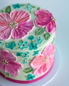 a cake decorated with pink and blue flowers