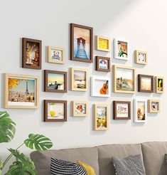 a living room filled with lots of framed pictures on the wall next to a couch