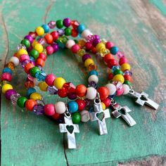 "7.5\" multicolor bracelet with small heart cross dangle." Multicolor Beaded Cross Jewelry, Multicolor Heart Beads Charm Bracelet, Multicolor Stretch Bracelet With Heart Beads, Multicolor Heart Beads Stretch Bracelet, Spiritual Multicolor Bracelets With Heart Beads, Spiritual Multicolor Heart Bracelets, Spiritual Multicolor Heart-shaped Bracelets, Multicolor Bracelet, Bracelets Diy