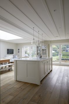 a large kitchen with an island in the middle and lots of windows on both sides