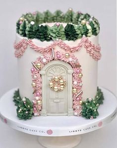 a white cake with pink and green decorations