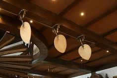 several lights hanging from the ceiling in a room with wooden beams and wood flooring