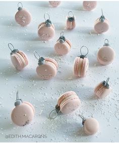 pink macaroons are arranged in rows on a white surface with drops of water