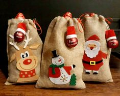 three bags filled with christmas decorations on top of a wooden table