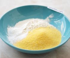 a blue bowl filled with yellow and white flour