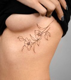 a woman's lower back tattoo with flowers on her stomach and the bottom part of her body