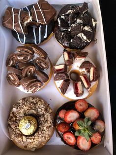 a box filled with assorted donuts and pastries on top of each other