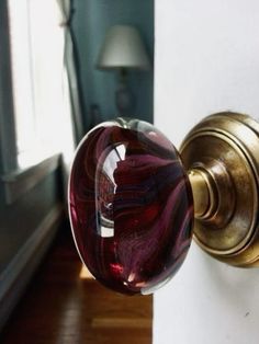 a close up of a door handle with a red glass ball on it's side