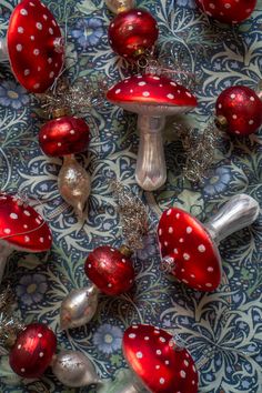 red and silver ornaments are arranged on a blue patterned tablecloth with white polka dots