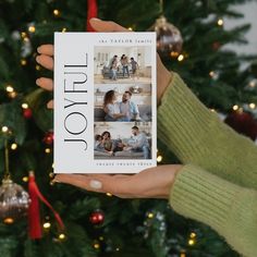 a person holding up a book in front of a christmas tree