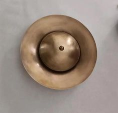 an antique brass door knob on a white wall with a small vase in the background