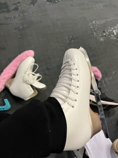 a pair of white shoes sitting on top of a black floor