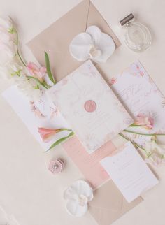 the wedding stationery is laid out with flowers