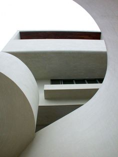 an abstract photo of the outside of a building with white walls and concrete columns on either side