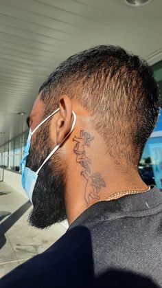 a man with a tattoo on his neck wearing a surgical mask to protect him from the sun