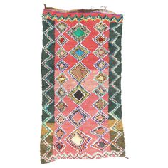 an old rug with different colors and patterns on it's sides, including green, pink