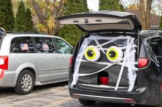 the back end of a car with an open trunk and eyes painted on it's face