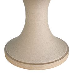 a white vase sitting on top of a wooden stand