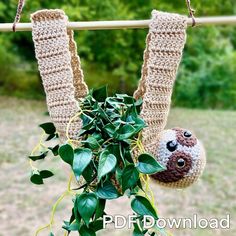 there is a stuffed animal hanging on the clothes line next to a plant with leaves