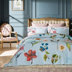 a bedroom with blue walls and floral bedding