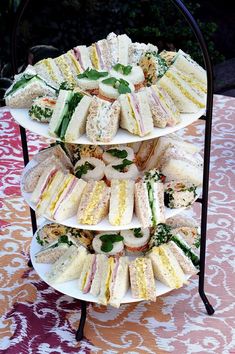 a three tiered tray with sandwiches on it