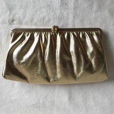 Vintage sparkly gold faux leather evening bag. Fabric gathered into covered metal frame. Fold over front clasp. Chain handle folds into bag so it can be used as clutch. Fabric lining Label: None Era: 1960s - 1970s Materials: Faux leather, metal Colors: Gold Strap/Handle: Chain Closure: Top clasp Measurements, laid flat, in inches: Drop: 5 Depth: 5.5 Width: 1 Length: 10.25 Condition: Good condition, some wear to edges, some marks to lining Luxury Baguette Clutch With Gold-tone Hardware, Cheap Gold Faux Leather Shoulder Bag, Cheap Gold Shoulder Bag With Handles, Affordable Vintage Gold Bags, Affordable Vintage Gold Evening Bag, Cheap Vintage Gold Bags, Late 80s Fashion, Gold Clutch Bag, Cute Clothing Stores