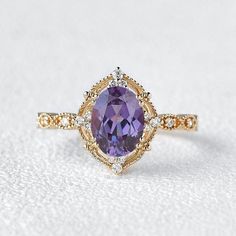 a ring with a large purple stone in the center and diamond accents on each side