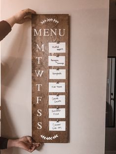 a person holding up a menu board with the words menu written in white on it