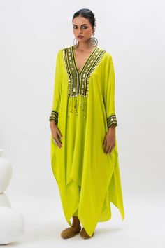 Neon green kaftan kurta with hand embroidered ajrakh border lace on yoke in front. Paired with stitched wrap skirt.
Components: 2
Pattern: Embroidered
Type Of Work: Ajrakh, Sequin, Zari, Thread
Neckline: V Neck
Sleeve Type: Batwing
Fabric: Satin
Color: Green
Other Details: 
Tassel details
Asymmetric hem
Occasion: Mehendi and Haldi - Aza Fashions Traditional Green V-neck Tunic, Green Maxi Length Kaftan For Festivals, Green Maxi-length Kaftan For Festivals, Green Kaftan With Resham Embroidery For Festivals, Green Dabka Kaftan For Eid, Green Bohemian Kaftan For Festive Occasions, Bohemian Green Straight Kurta Tunic, Green Bohemian Straight Kurta Tunic, Traditional Green Kaftan For Festive Occasions