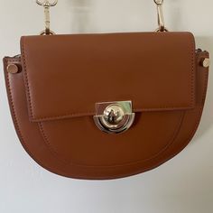 This Bag Is Pristine And Unused. It Has An Inside Interior Phone Pocket Compartment And Outside Zipper Pocket And A Multiple Hole Adjustable Strap. The Front Clasp Is Magnetized. Everyday Clutch Bag With Metal Hardware, Chic Brown Saddle Bag With Metal Hardware, Brown Crossbody Bag With Magnetic Closure, Everyday Brown Saddle Bag With Metal Hardware, Brown Saddle Bag With Gold-tone Hardware For Shopping, Brown Shoulder Flap Bag With Metal Hardware, Brown Clutch Bag With Magnetic Closure, Versatile Brown Flap Bag With Magnetic Closure, Versatile Brown Satchel With Magnetic Closure