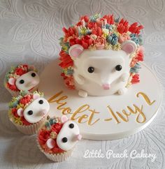 there is a cake with cupcakes on the plate and an animal figurine next to it