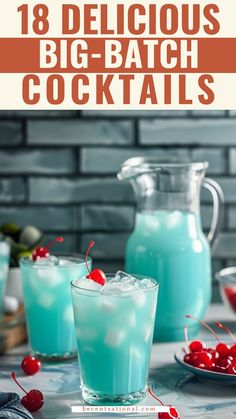 two glasses filled with blue liquid and cherries on the side, next to a pitcher