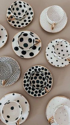 black and white polka dot plates are arranged on a table with gold trimmings