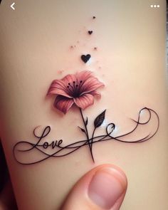 a person holding a flower with the word love written on it's back side