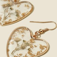 two heart shaped earrings with flowers on them