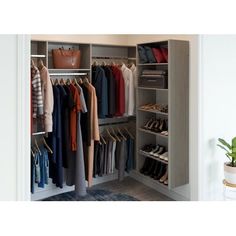 an open closet with clothes and shoes on hangers