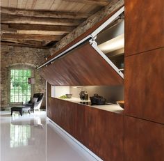 an open kitchen and living room area in a stone walled building with exposed ceiling beams