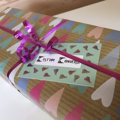 a present wrapped in brown paper with purple ribbon