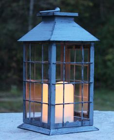 a lantern with three lit candles in it