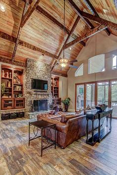 a large living room with wood floors and vaulted ceiling