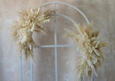 two dried flowers are placed in front of a window