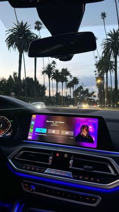 the dashboard of a car with an image of a woman on her cell phone and palm trees in the background