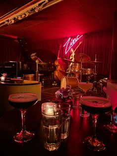 a bar with two martinis and some music instruments on the table in front of it