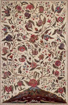 an intricately designed rug with flowers and birds in the center, on a white ground