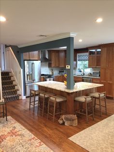 an open kitchen and living room area with hardwood floors, blue walls, and white counter tops