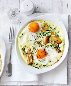 two plates of food on a table with silverware and utensils next to them